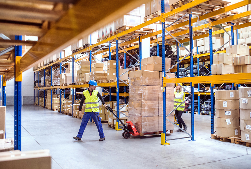 Man pulling a pallet truck in a warehouse