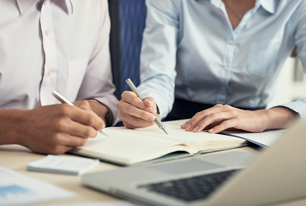 Business people writing in a notepad